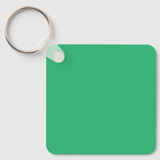 a green background with a white border keychain (Front)
