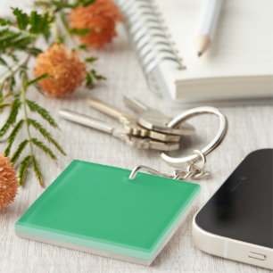 a green background with a white border keychain