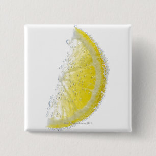 A juicy ripe organic lemon wedge fruit submerged button