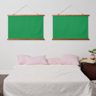 A lush green backdrop with a clean white square po hanging tapestry