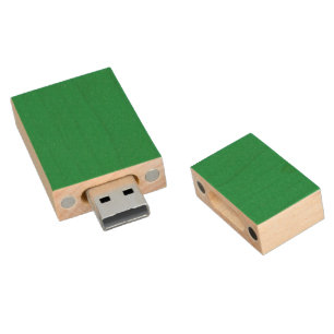 A lush green backdrop with a clean white square po wood flash drive