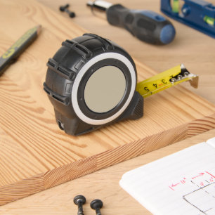 a man in a suit and tie standing in front of a wal tape measure