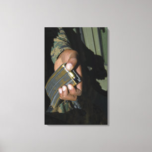 A Marine loads blank ammunition rounds Canvas Print
