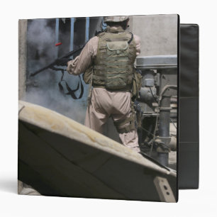 A military policeman uses a breaching round 3 ring binder