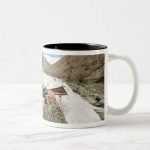 A Mujahadeen Guard walks with US Military membe Two-Tone Coffee Mug