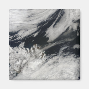 A pale gray ash plume blows from the summit magnet