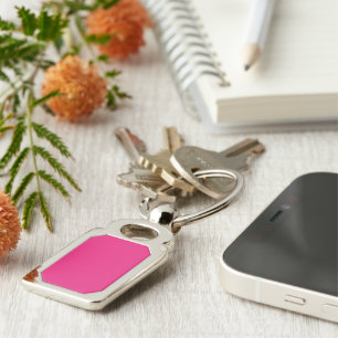 a pink background with a black border keychain
