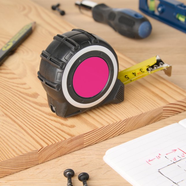 a pink background with a black border tape measure (Woodwork)