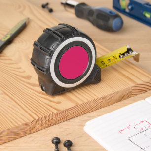 a pink background with a white border tape measure