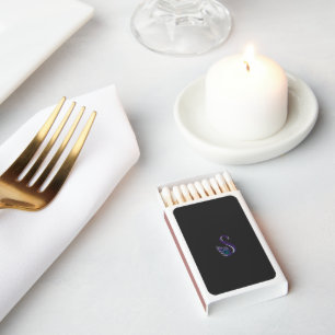 a purple and green peacock feather on a black back matchboxes