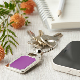 a purple background with a white border keychain