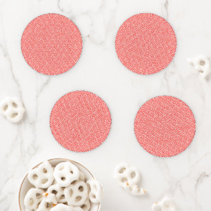 a red and white background with a pattern coaster set