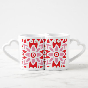 a red and white pattern with a flower on it coffee mug set