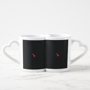 a red flower with a black background coffee mug set