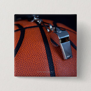 A referee's whistle rests on top of a button