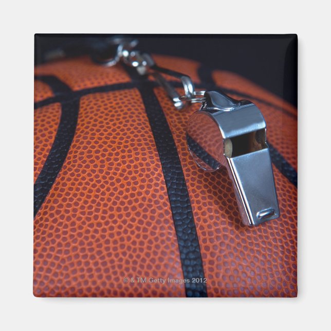 A referee's whistle rests on top of a magnet (Front)