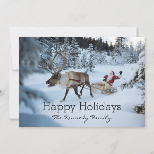 A reindeer pulling Santa Claus and his sleigh Holiday Card