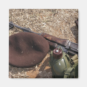 A rifle, military cover and canteen magnet