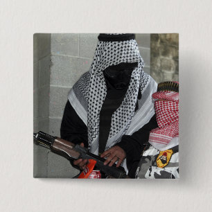 A role-playing enemy aggressor arms a dummy pinback button