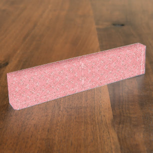 A rug with a red and pink motif features a decorat desk name plate