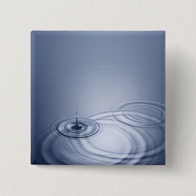 A single droplet of water falling into a calm pinback button (Front)