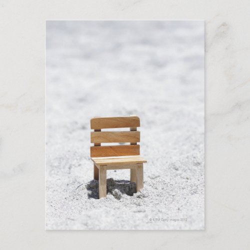 A small chair in the sandy beach postcard