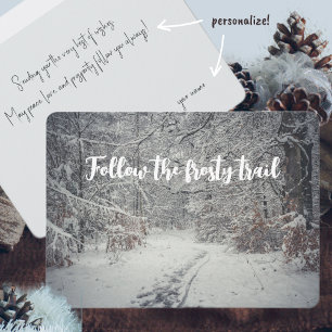 A snow-covered path through a winter forest card