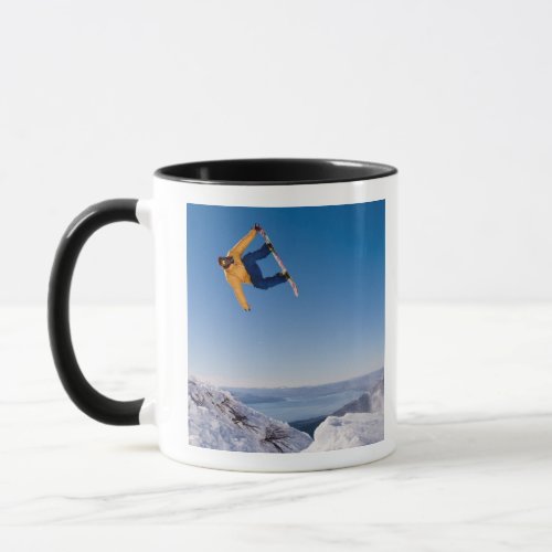 A snowboarder spins off a jump in Argentina Mug