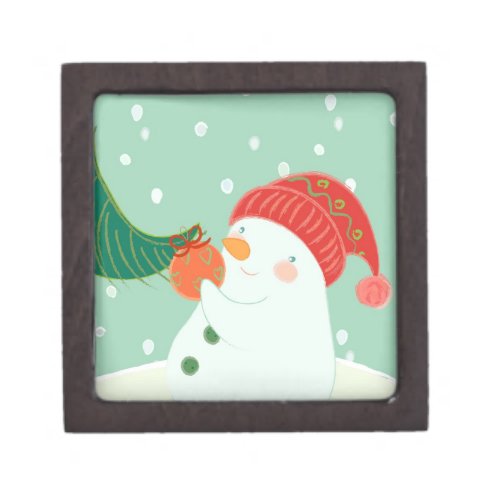 A snowman hanging an ornament on a tree keepsake box