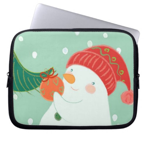 A snowman hanging an ornament on a tree laptop sleeve
