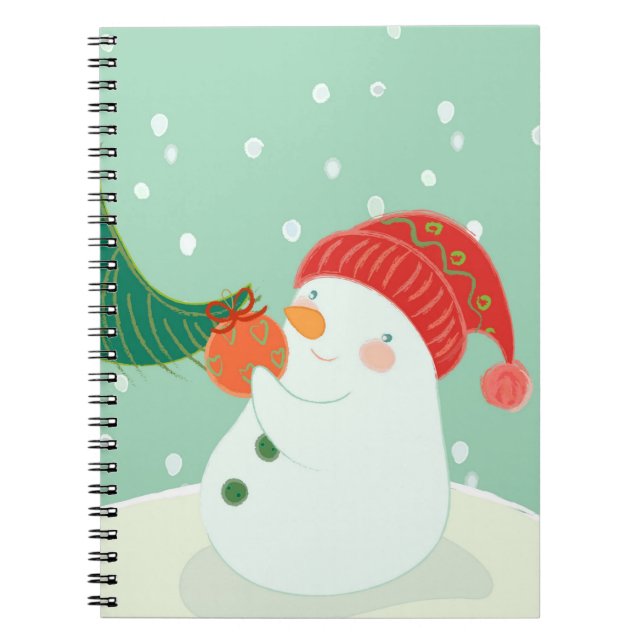 A snowman hanging an ornament on a tree notebook (Front)