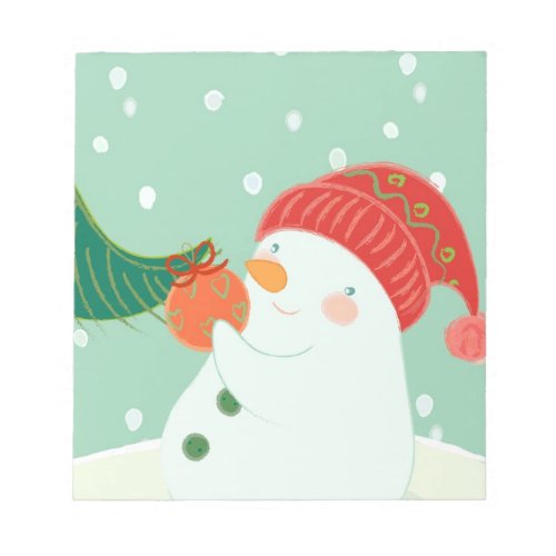 A snowman hanging an ornament on a tree notepad