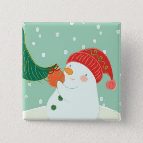 A snowman hanging an ornament on a tree pinback button