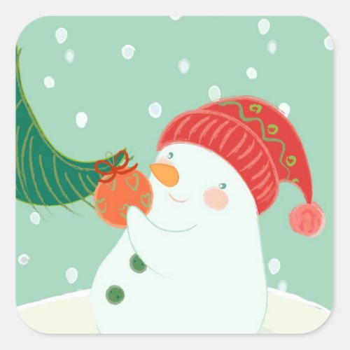A snowman hanging an ornament on a tree square sticker