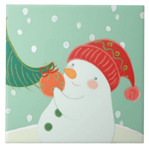 A snowman hanging an ornament on a tree tile