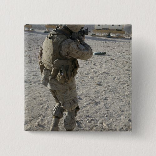 A soldier engages his target on a shooting rang button