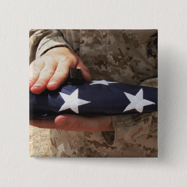 A soldier holds the United States flag Pinback Button (Front)