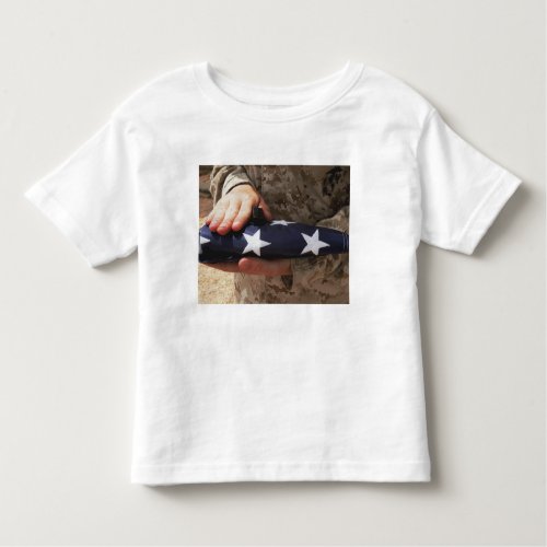 A soldier holds the United States flag Toddler T_shirt