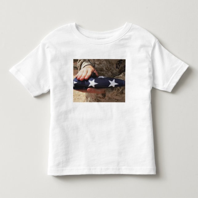 A soldier holds the United States flag Toddler T-shirt (Front)