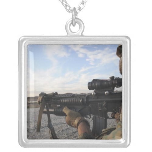 A soldier sights in to fire on a target silver plated necklace