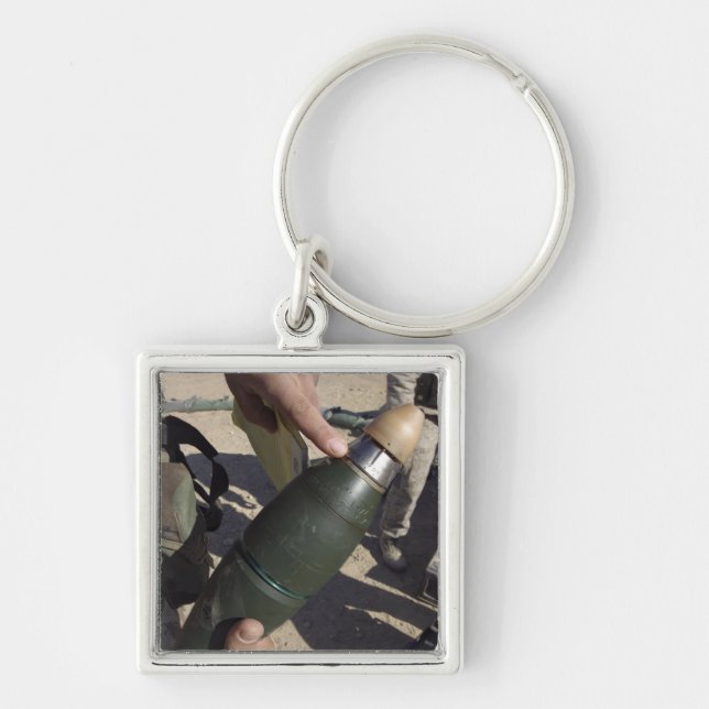 A squad leader points to a delay setting keychain (Front)