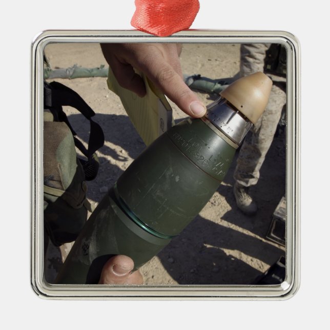 A squad leader points to a delay setting metal ornament (Front)