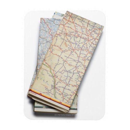 A stack of folded road maps on a white magnet
