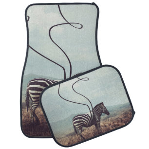 A surreal image of a zebra and two of its black st car floor mat