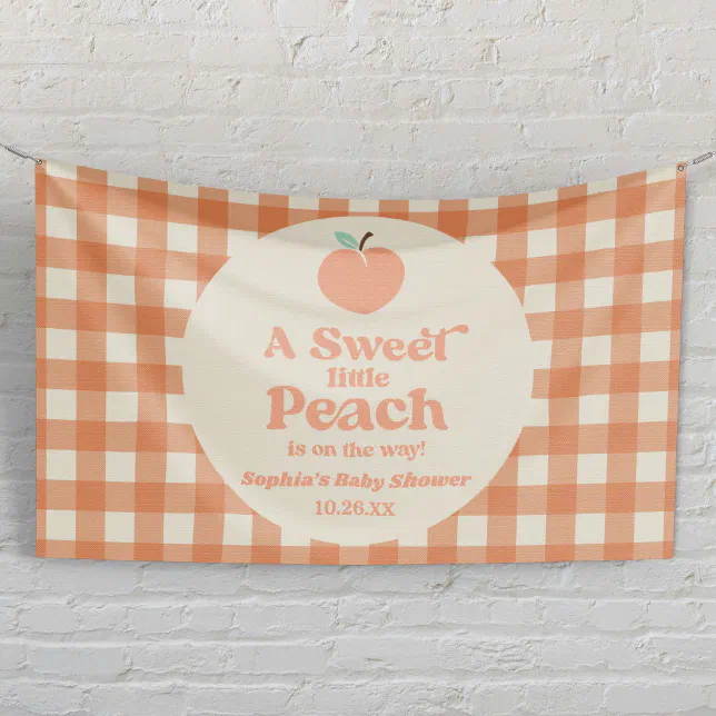 A baby shower banner is hung up against a white brick wall to welcome guests!
