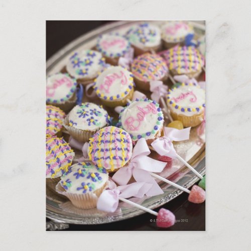 A tray of baby rattle cupcakes at a baby shower invitation postcard