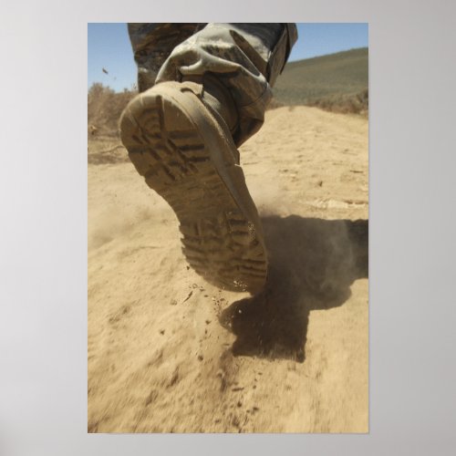 A US soldier walks along a dirt path Poster