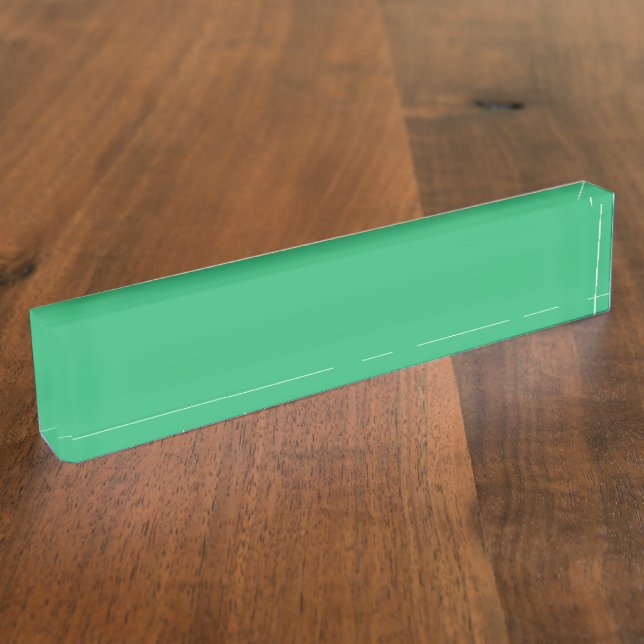 A vibrant green leaf with prominent veins and a de desk name plate (Side)