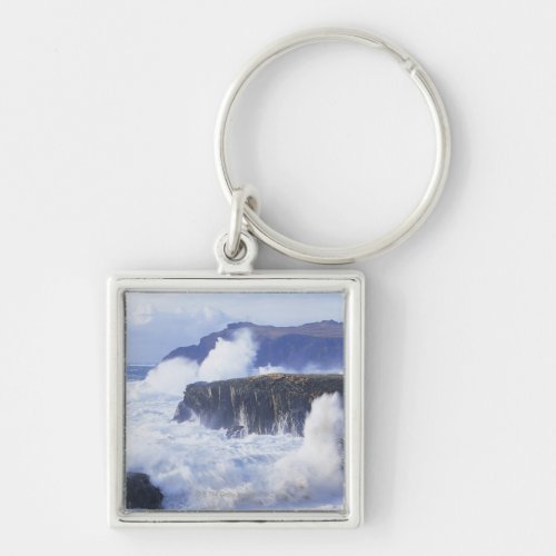 a view of the waves crashing against rocks keychain