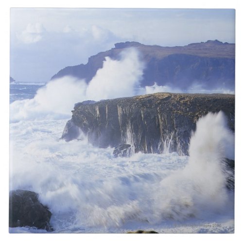 a view of the waves crashing against rocks tile